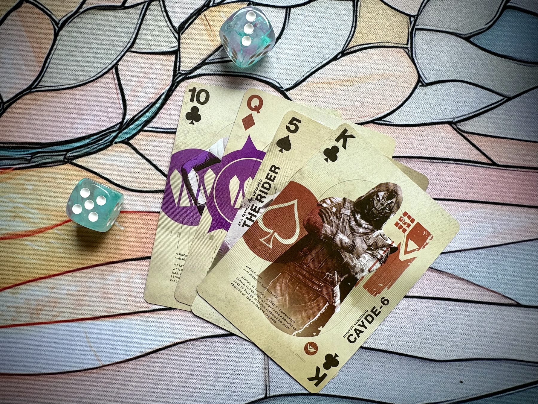 Destiny playing cards and two dice on a colorful table